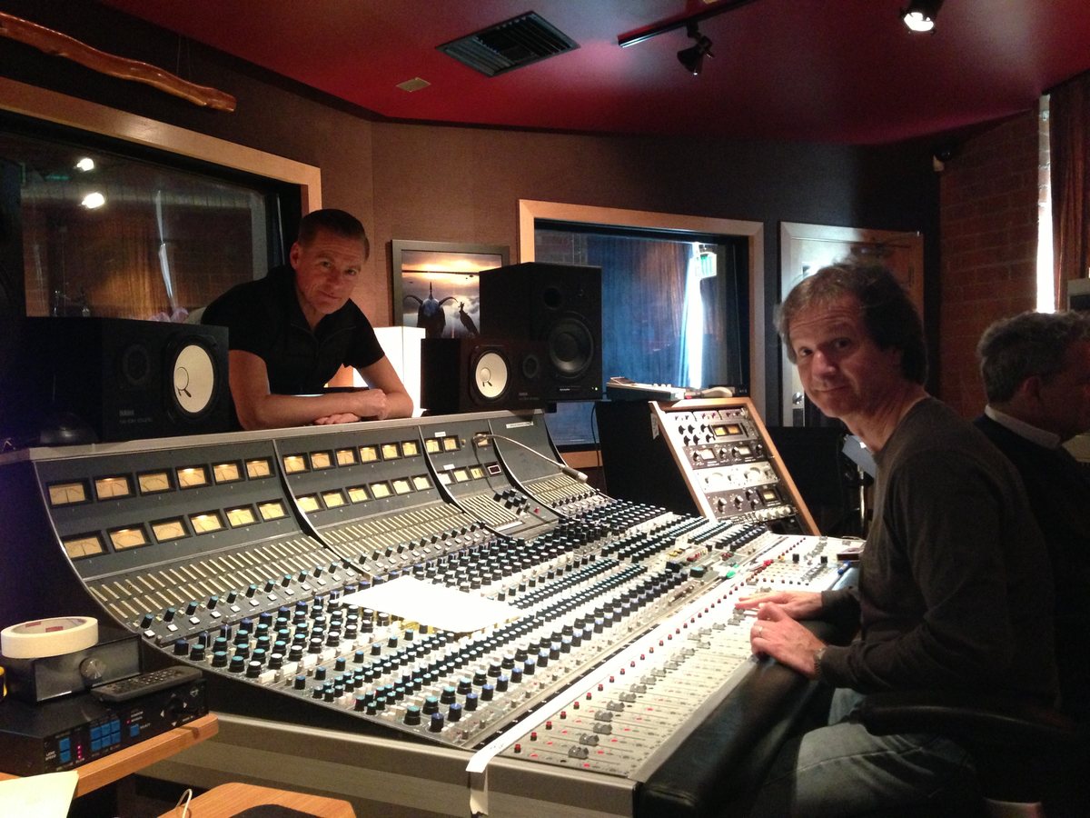 Bryan Adams leaning over the console while Bob Clearmountain mixes