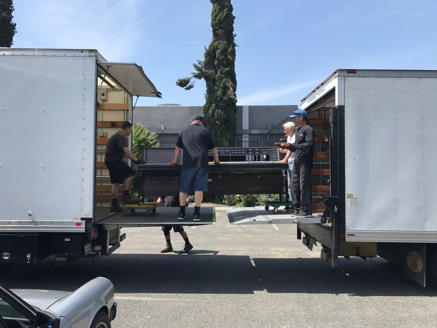 The cartage crew moving the API console between two trucks